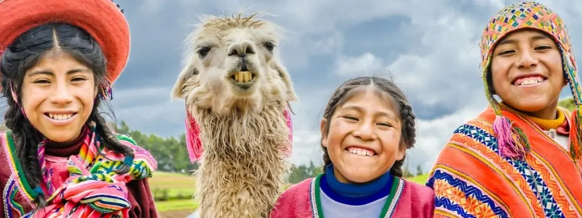 group of smiling people with an alpaca