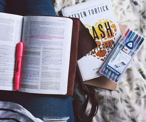 guy studying on the bed