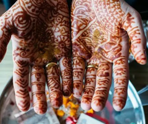 Hands painted with red mehndi 