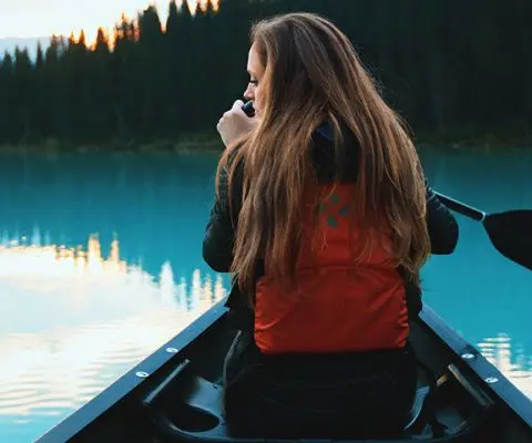 Girl paddling in lake louise