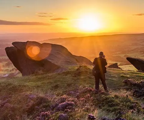 Man taking photo of heather in the sunset