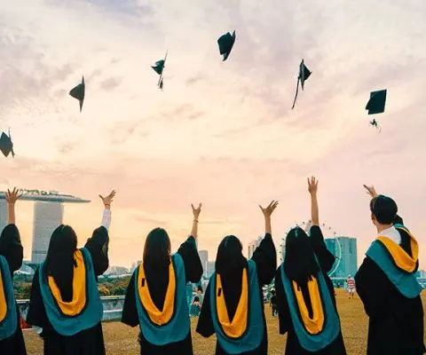 graduates throwing their caps