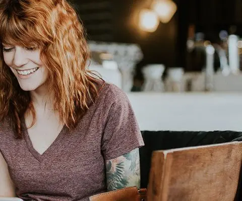 Tattooed woman with laptop
