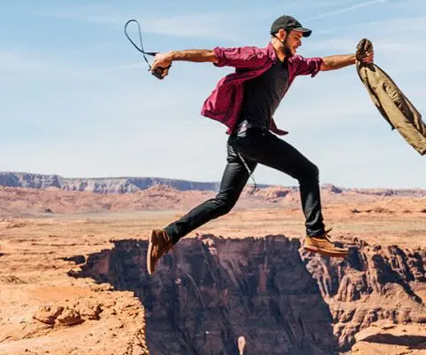 person jumping on cliffs