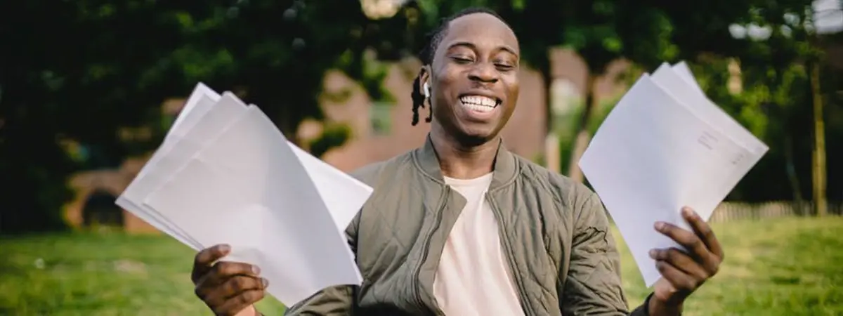 person smiling while holding pieces of paper