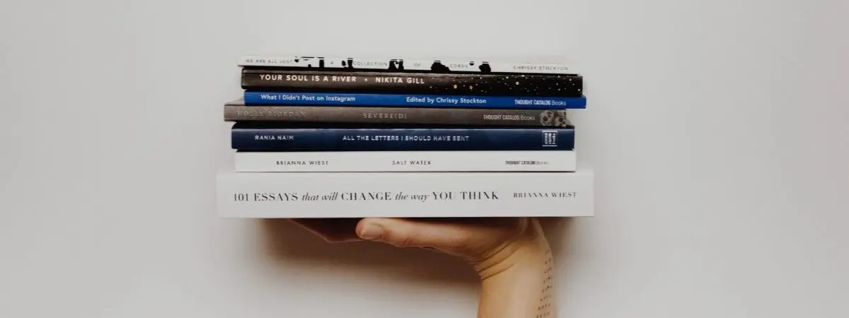 hand holding stack of books