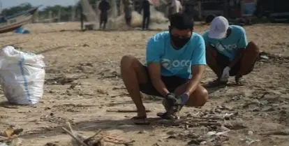 people sitting on brown sand cleaning the beach