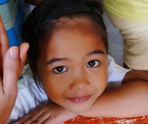 volunteer hand touching small girl’s hand