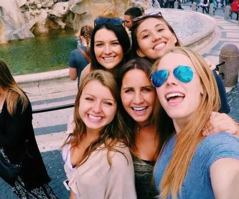 Friends in front of the Foundation of Four Rivers in Piazza Navona, Rome, Italy