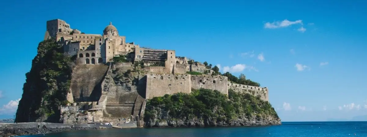 castle on top of cliff surrounded by water